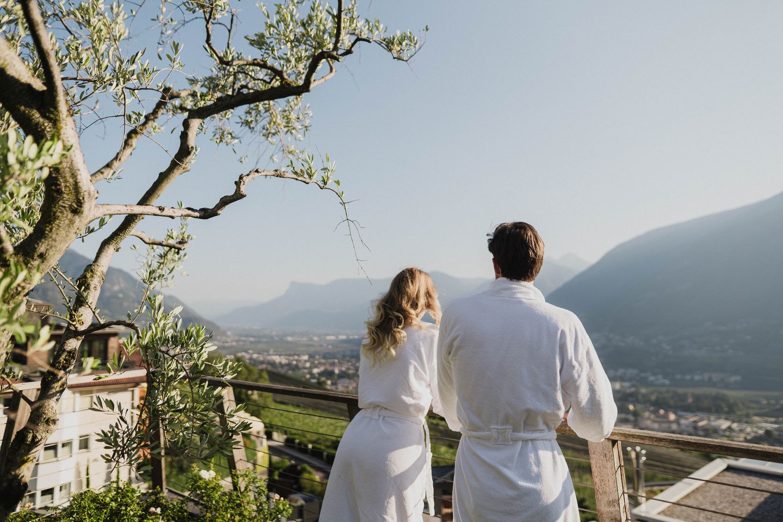 Paar in Bademänteln genießt die Aussicht auf Meran im Erika-Garten in Dorf Tirol, Südtirol