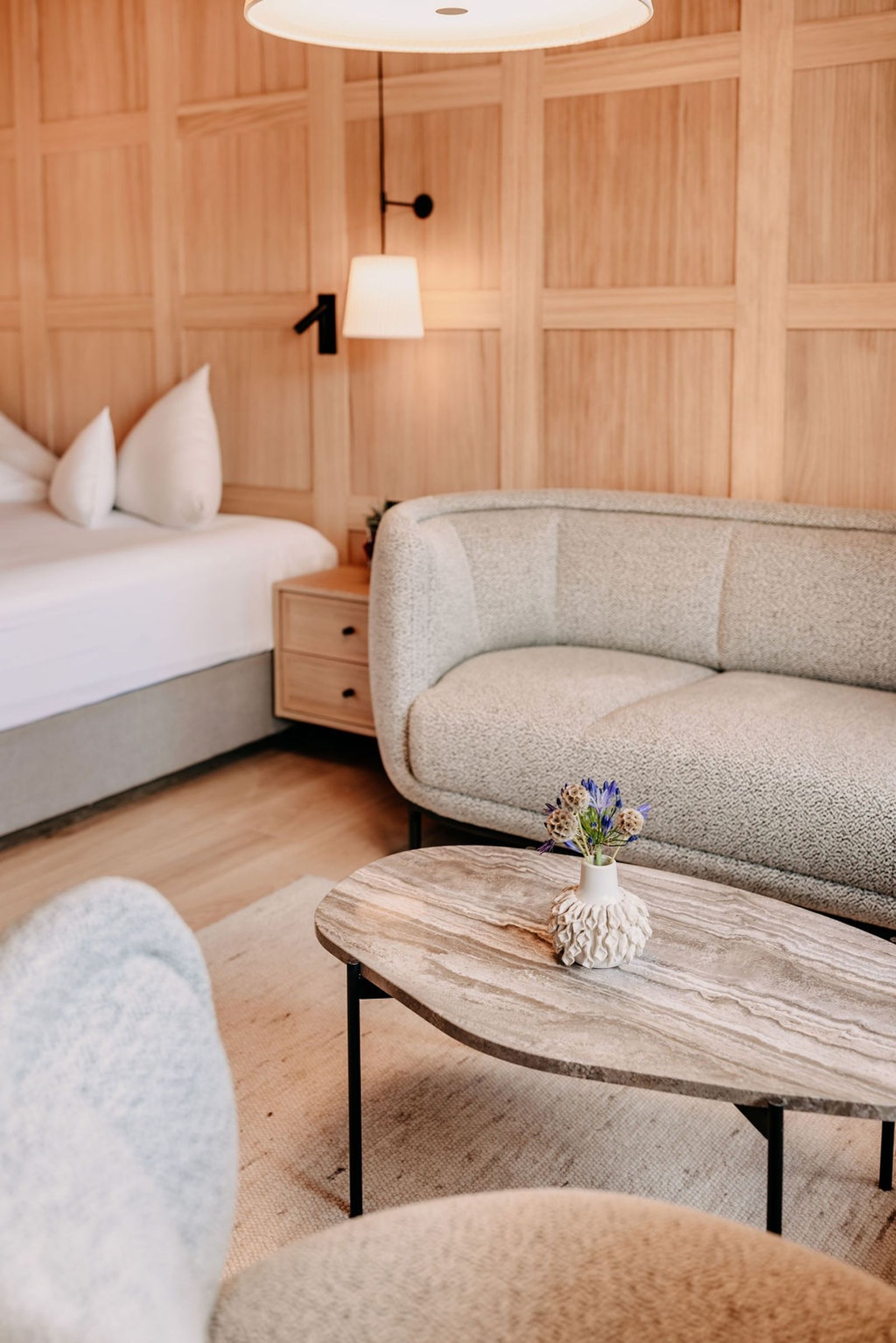 Loungebereich mit Tisch, Holztäfelung an der Wand im Hintergrund.