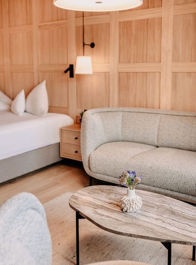 Loungebereich mit Tisch, Holztäfelung an der Wand im Hintergrund.