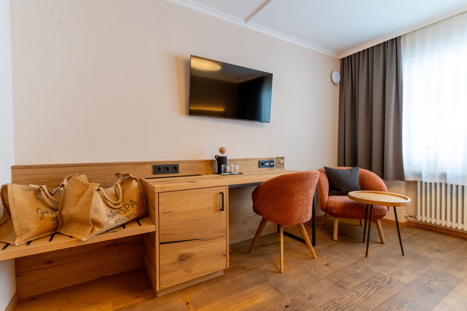 Sitzgelegenheit mit Schreibtisch und Fachbildschirm-TV im Doppelzimmer Heimatglück