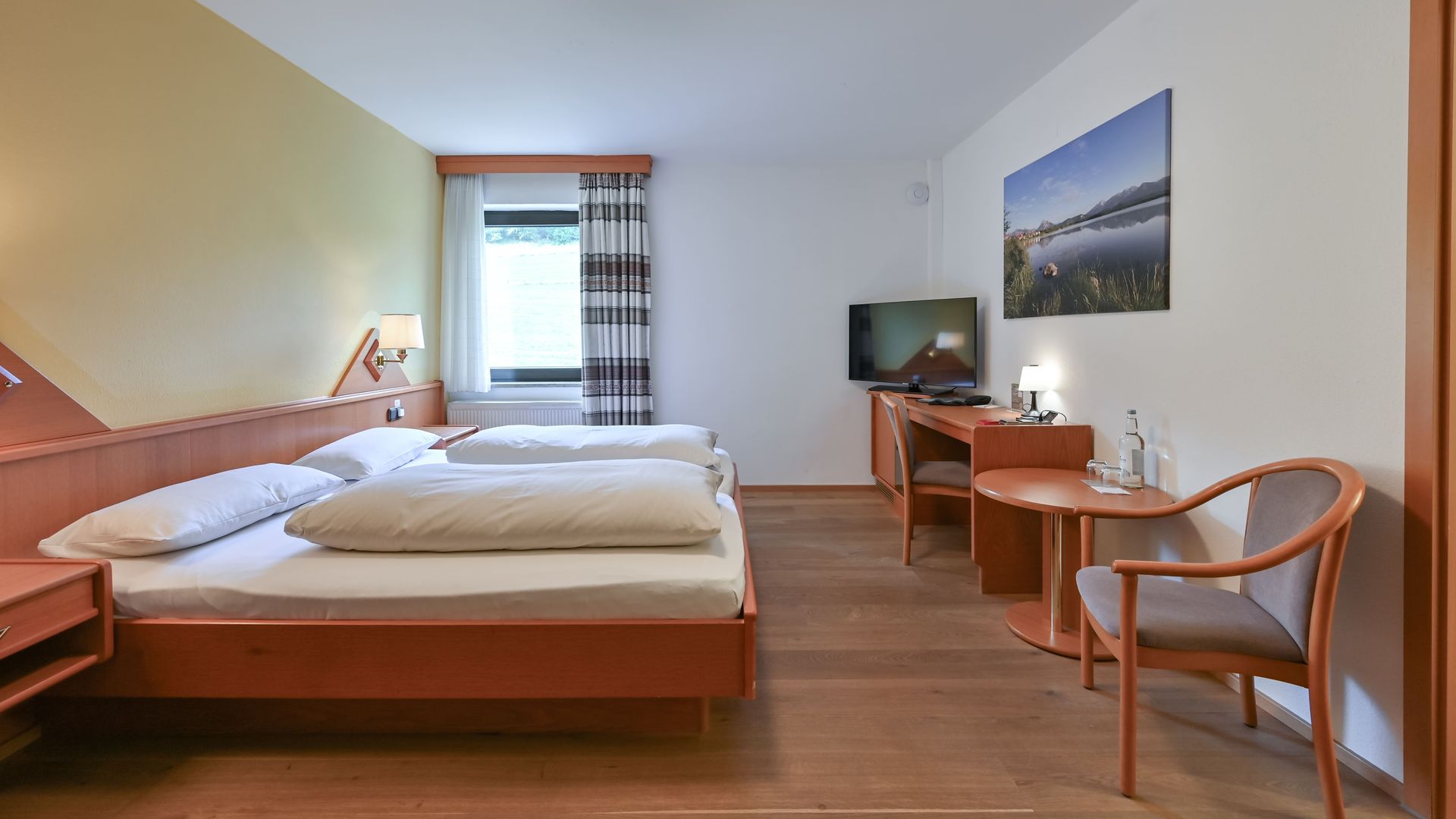 Biohotel Eggensberger Doppelzimmer Basis Almwiese mit Sitzecke und Ausblick zur Wiese