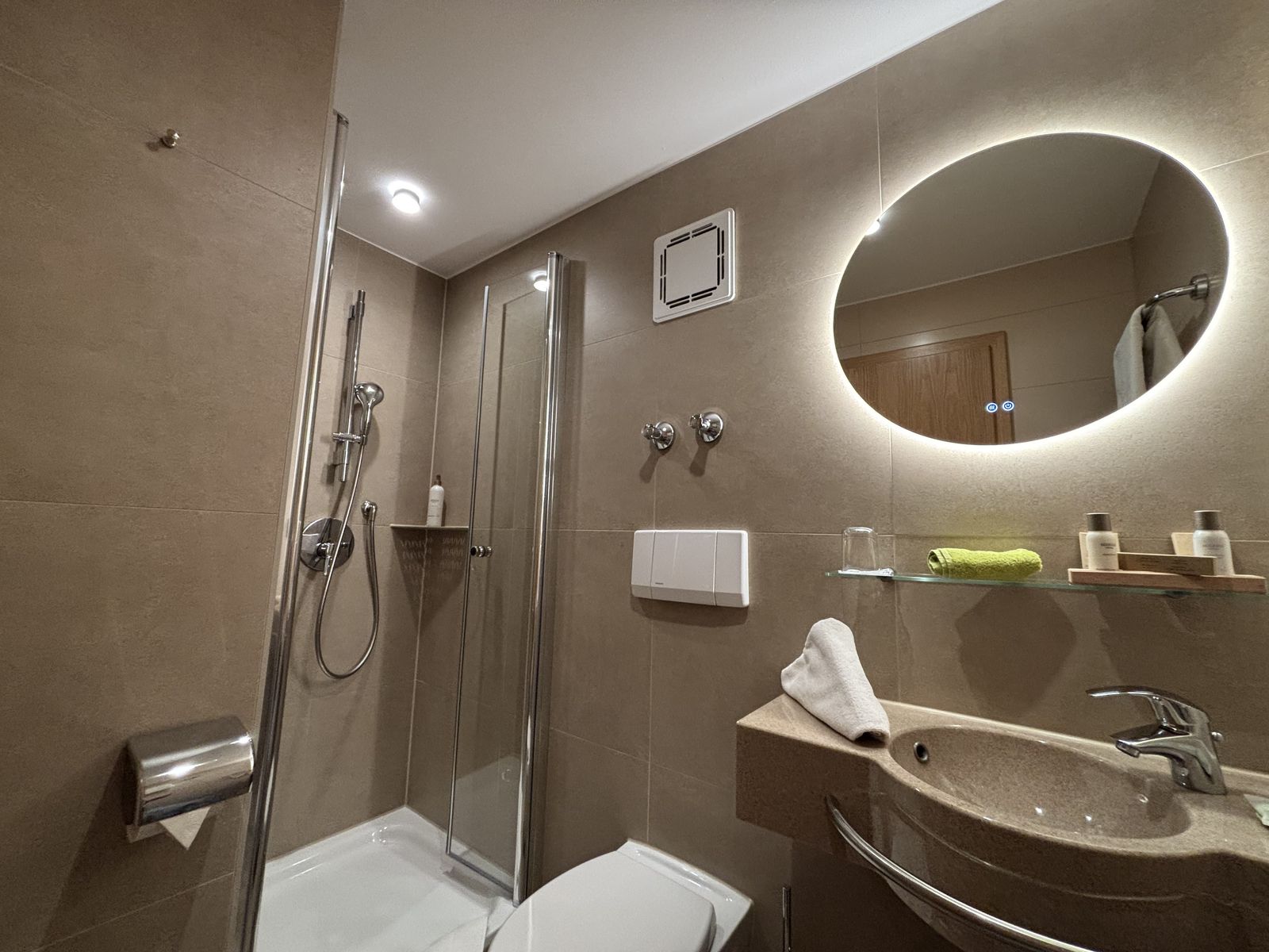 Badezimmer des Einzelzimmers "klein aber fein" im Wellnesshotel mit Spiegel, Waschbecken, Toilette und Dusche