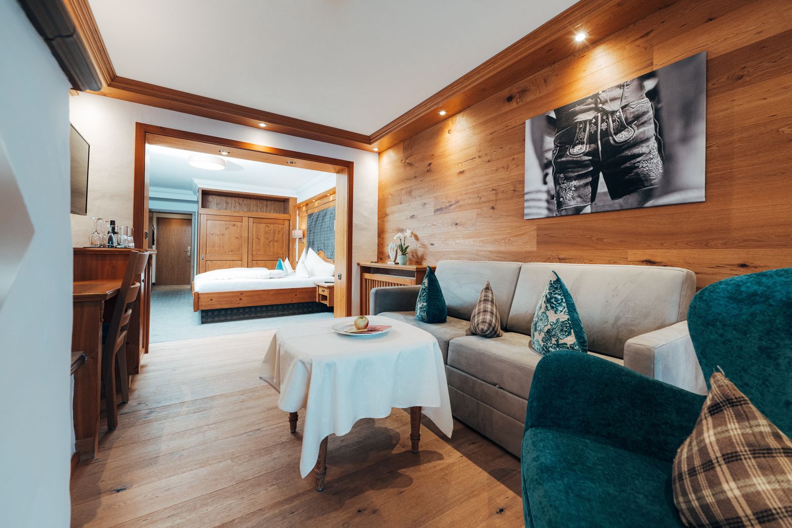 ein gemütliches Doppelzimmer im alpenländischen Stil mit Parkettboden und komfortabler Sitzecke