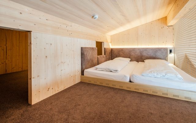 Kinderhotel Allgäuer Berghof – Schlafzimmer der Familiensuite Häschengrube XL mit Blick auf die Allgäuer Alpen