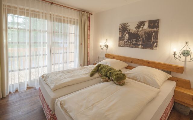 Kinderhotel Allgäuer Berghof – Schlafzimmer im Bauernhof Chalet-Edelweiß mit Balkon auf die Allgäuer Alpen