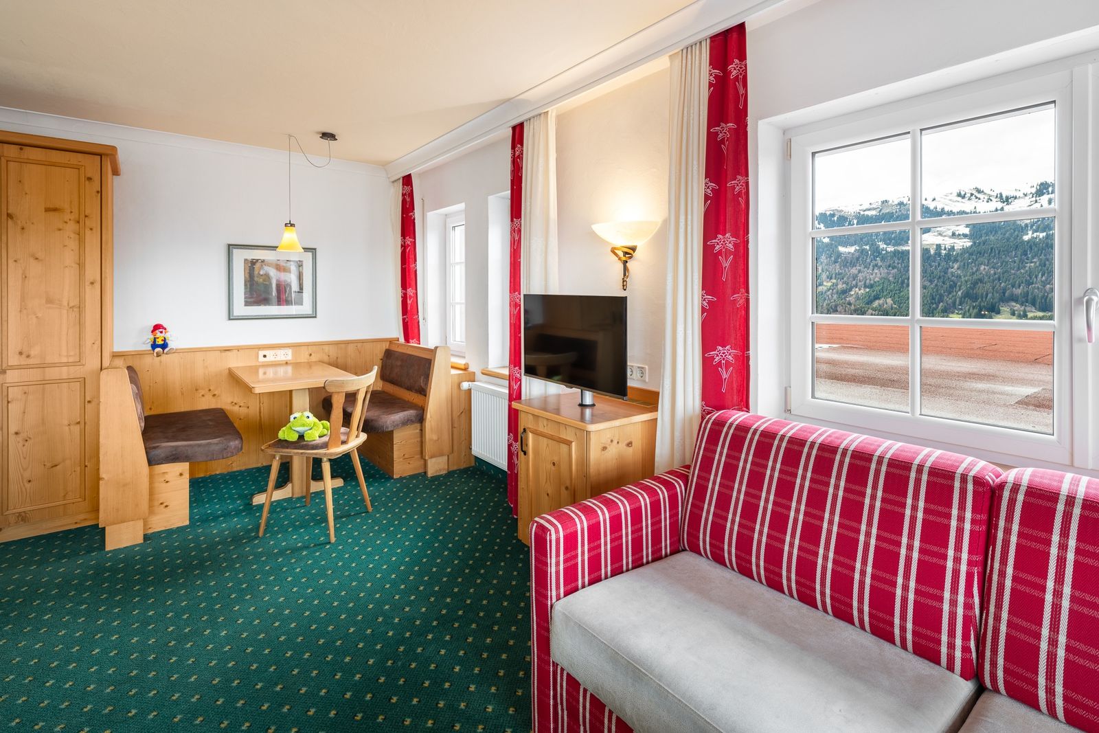 Kinderhotel Allgäuer Berghof – Wohnzimmer Familiensuite Kuhmoggl mit Blick auf die Allgäuer Alpen