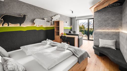 Kinderhotel Allgäuer Berghof – Wohnzimmer Familiensuite Schafgemach mit Blick auf die Allgäuer Alpen