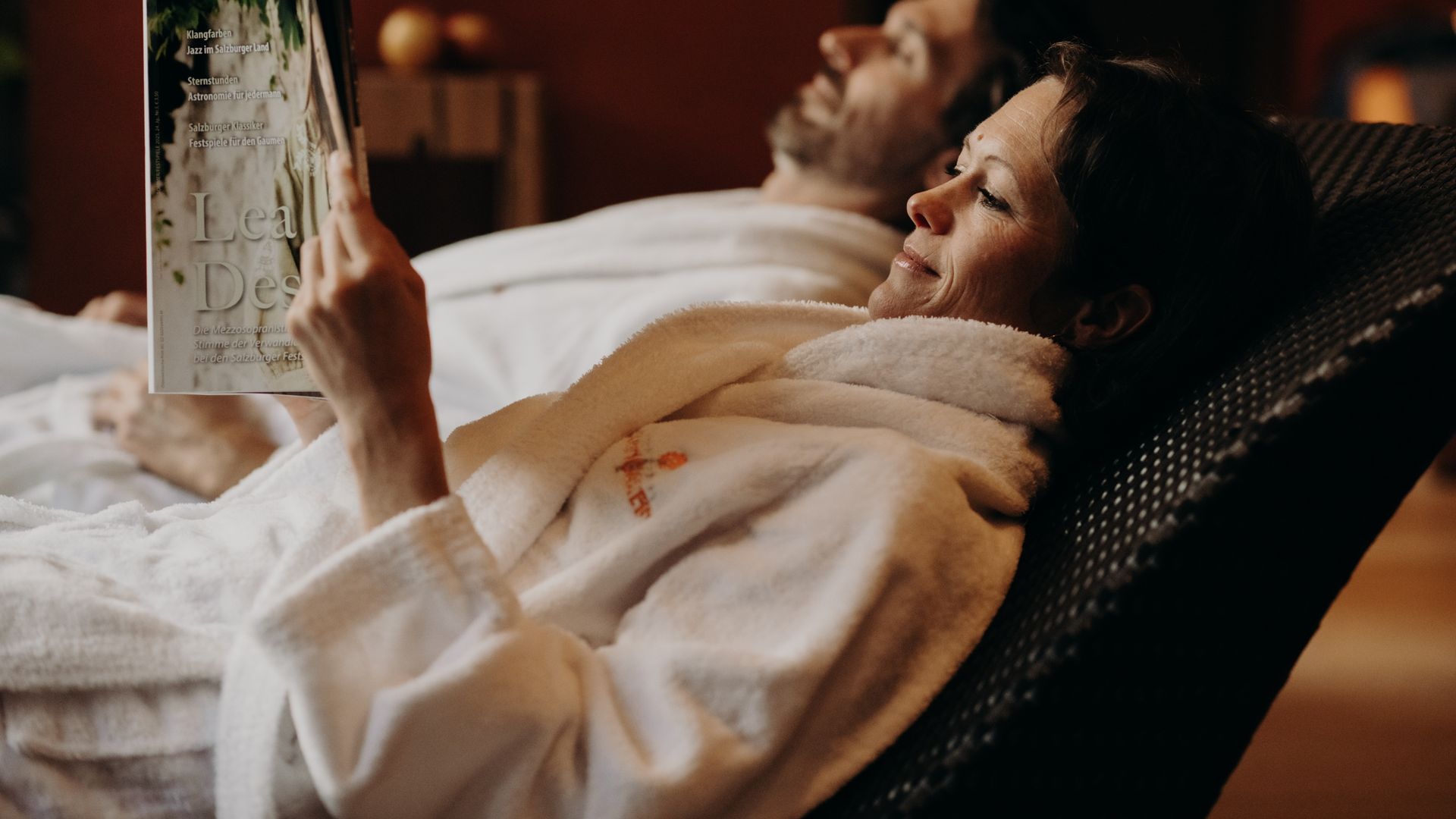 Paar im Bademantel auf Ruheliegen im Wellnessbereich – Entspannung und Erholung im Hotel Sonngastein.