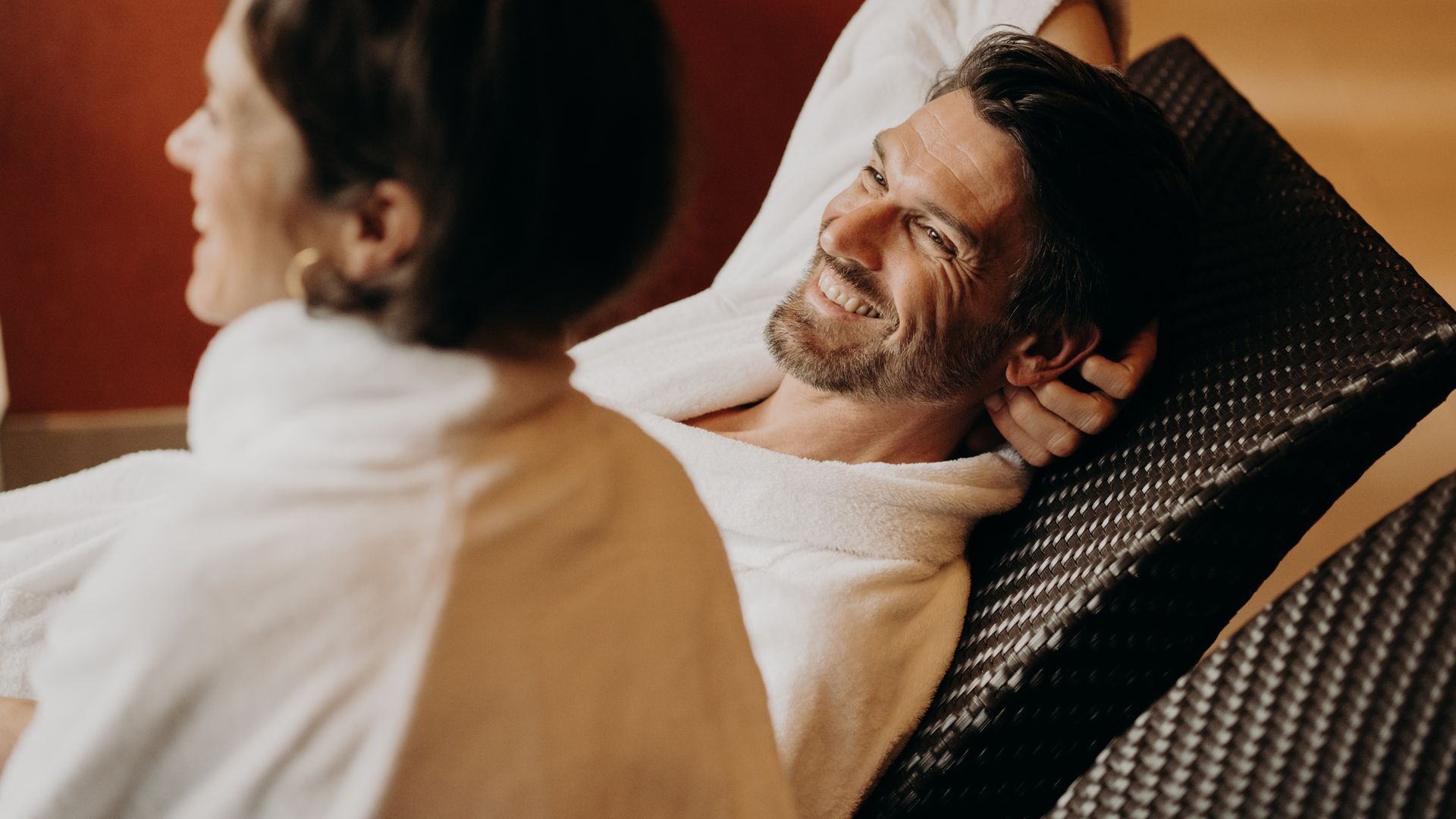 Paar im Bademantel auf Ruheliegen im Wellnessbereich – entspannte Auszeit im Hotel Sonngastein.