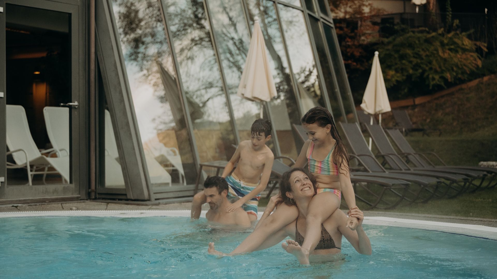 Familie im Außenpool des Hotel Sonngastein – Badespaß und Familienurlaub in Gastein.