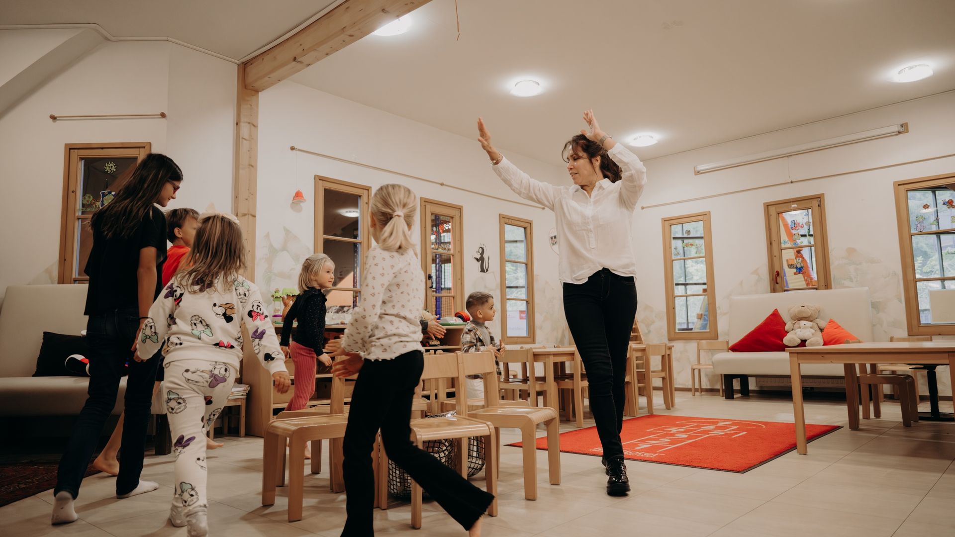 Kinder tanzen mit Betreuerin im Spielraum des Hotel Sonngastein.