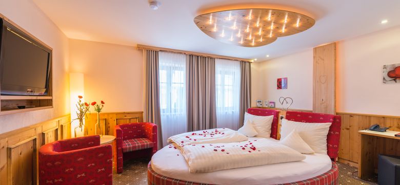 Doppelzimmer "Kuschelnest" mit großem, herzförmigen Bett und romantischem Ambiente.