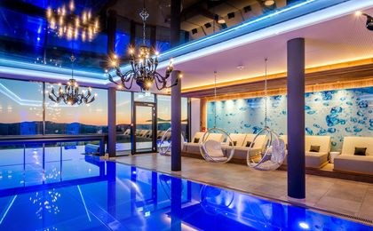 Beheizter Indoor-Pool mit mehreren Liegemöglichkeiten und besonderer Lichtkulisse.