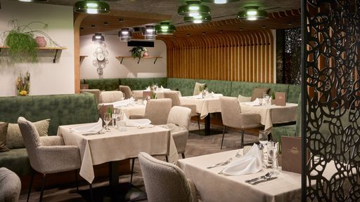 Restaurant Waldfee, tables laid with cloth napkins, beautiful atmosphere with wood paneling and decorations