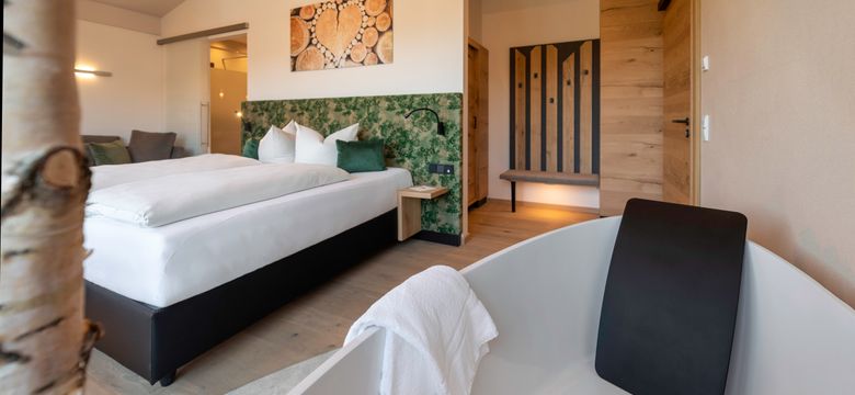 Gemütlich-modernes Doppelzimmer in braun- und Grüntönen mit freistehender Badewanne