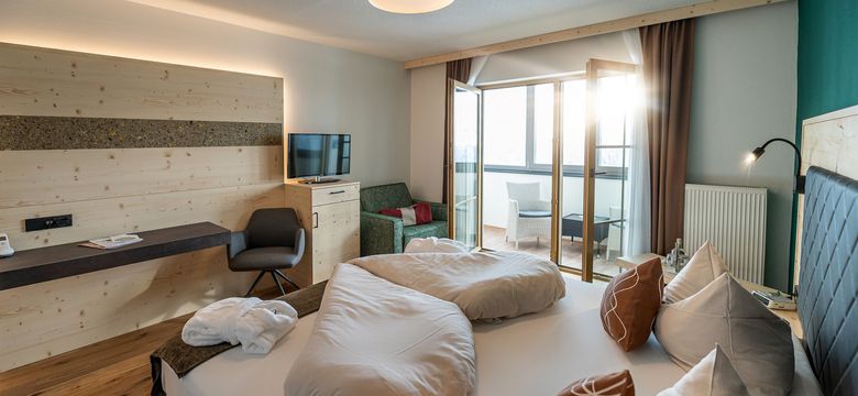 Zimmeransicht mit Blick vom Bett auf den kleinen Wintergarten