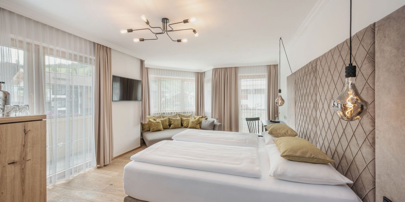 Helles, modernes Studio SÜDFLÜGEL im Hotel die HOCHKÖNIGIN in Maria Alm mit großen Fenstern, eleganter Einrichtung und stilvollen Details.