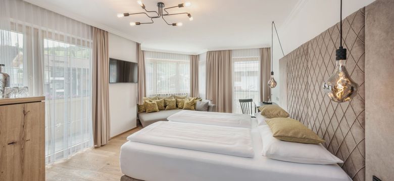 Helles, modernes Studio SÜDFLÜGEL im Hotel die HOCHKÖNIGIN in Maria Alm mit großen Fenstern, eleganter Einrichtung und stilvollen Details.