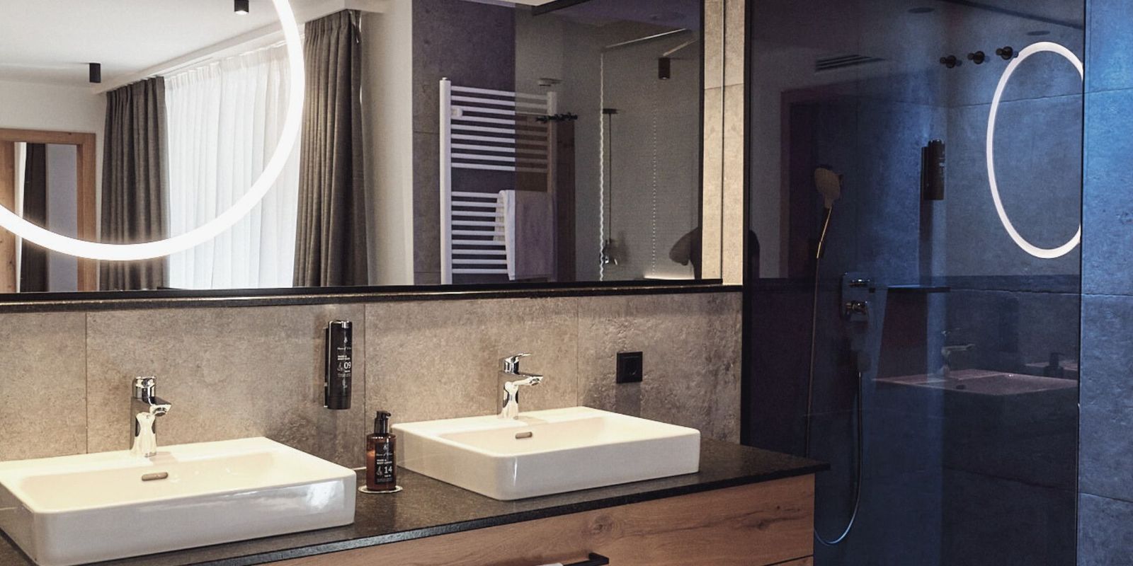 Das Badezimmer der HOCHKÖNIGIN vereint modernes Design mit luxuriösen Details: stilvolle Armaturen, klare Linien und eine harmonische Lichtinszenierung schaffen eine Atmosphäre von Ruhe und Eleganz.