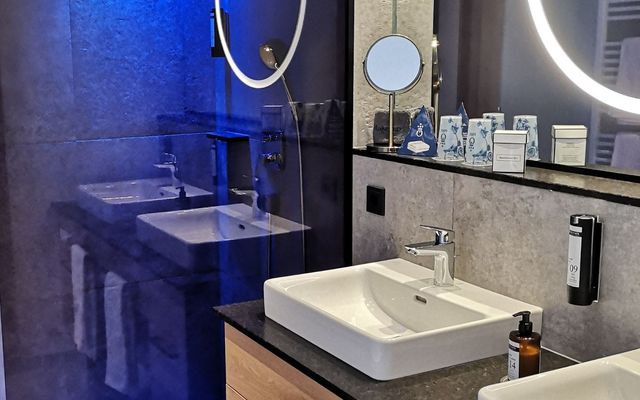 Das stilvolle Badezimmer mit Doppelwaschbecken in der HOCHKÖNIGIN überzeugt mit klaren Linien, eleganten Materialien und stimmungsvollem Lichtdesign. Ein Ort, der Luxus neu definiert – modern, edel und ganz entspannt in Maria Alm.