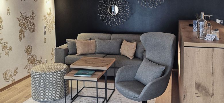 The suite lounge at the HOCHKÖNIGIN Hotel in Maria Alm blends modern elegance and cozy comfort with natural materials and refined design details.