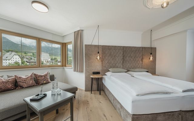 Zimmer im Hotel die HOCHKÖNIGIN mit Blick auf das Bett und tolle Aussicht auf die Berge